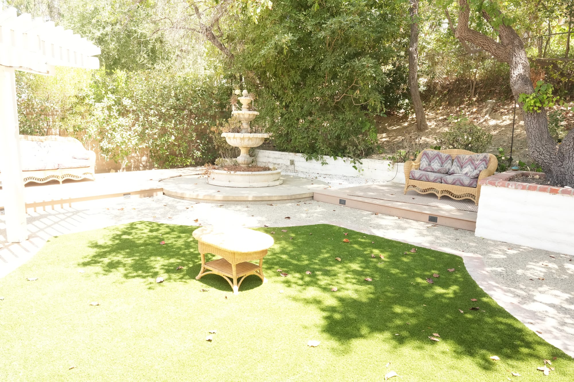 Backyard with fountain, seating, and hillside trees
